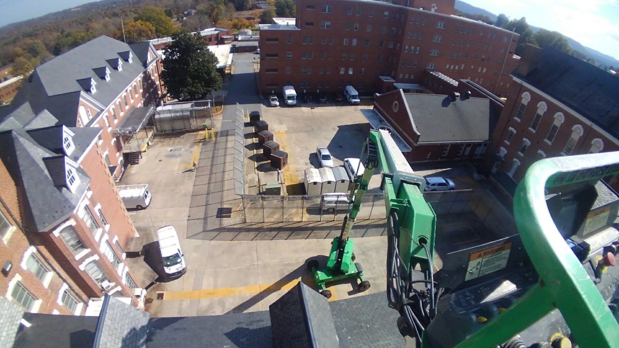 Aerial lift working above brick campus buildings