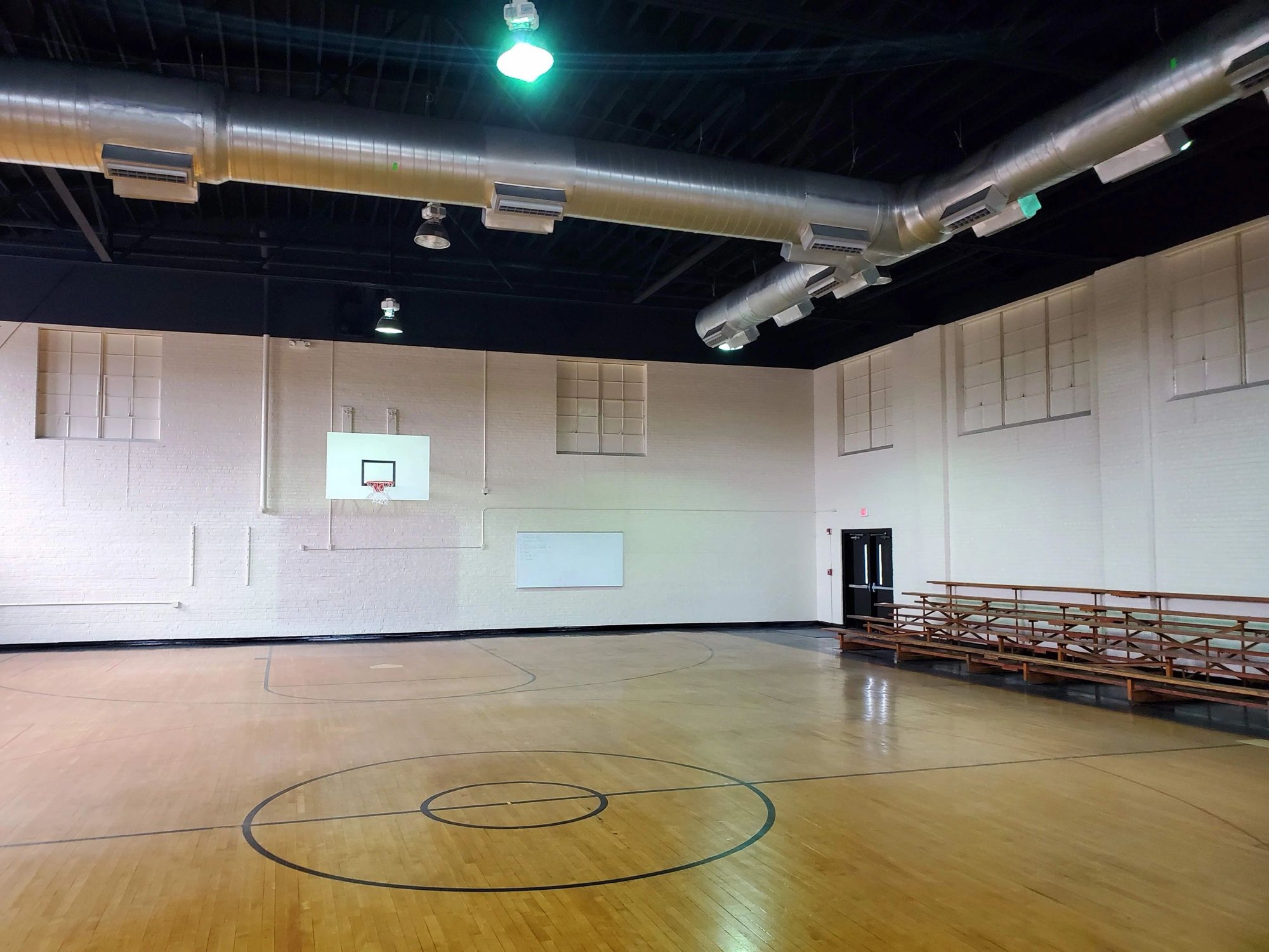 Gymnasium with freshly painted white walls and a black ceiling
