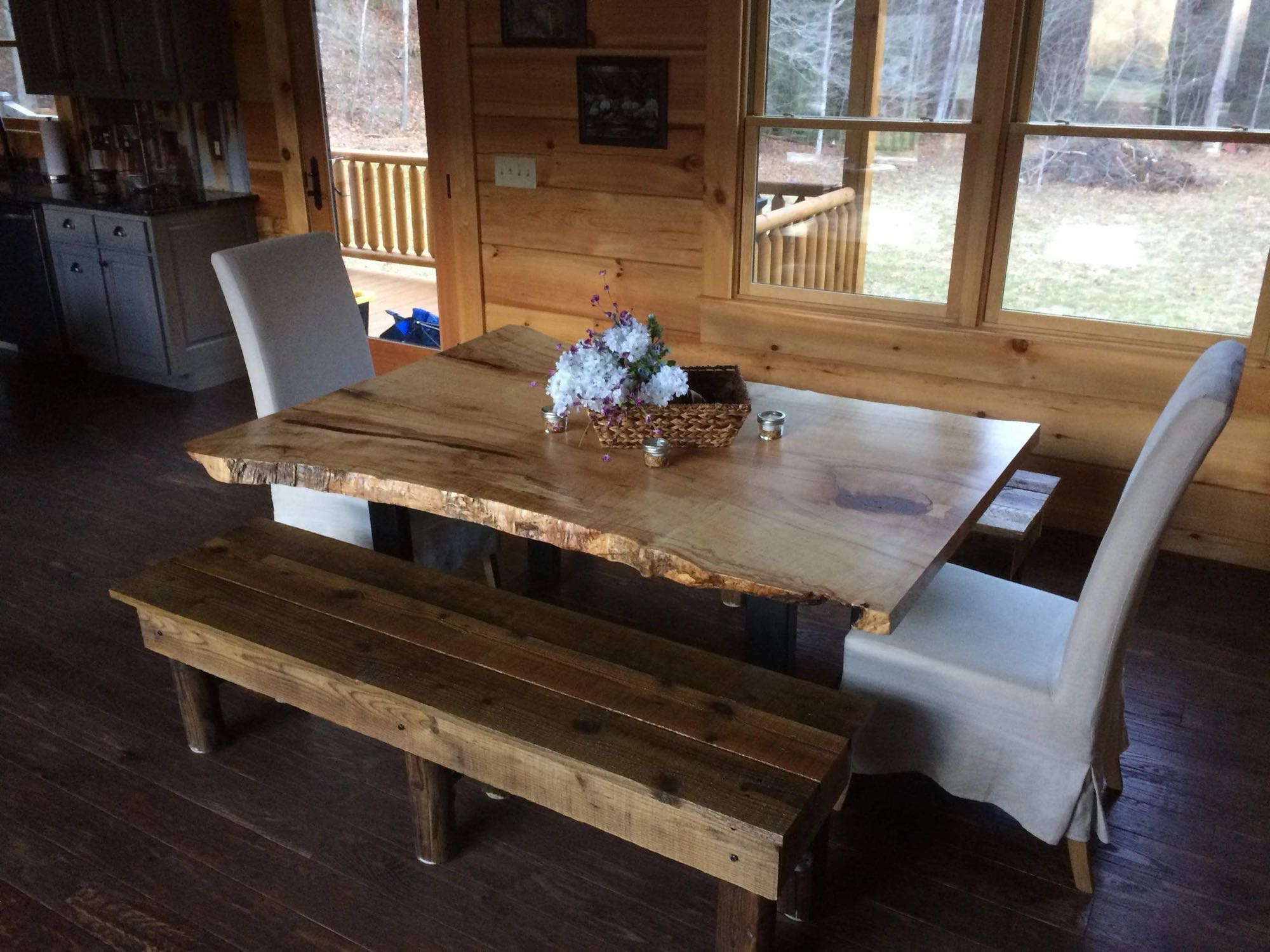 Dining room with natural pine plank walls and a live-edge table