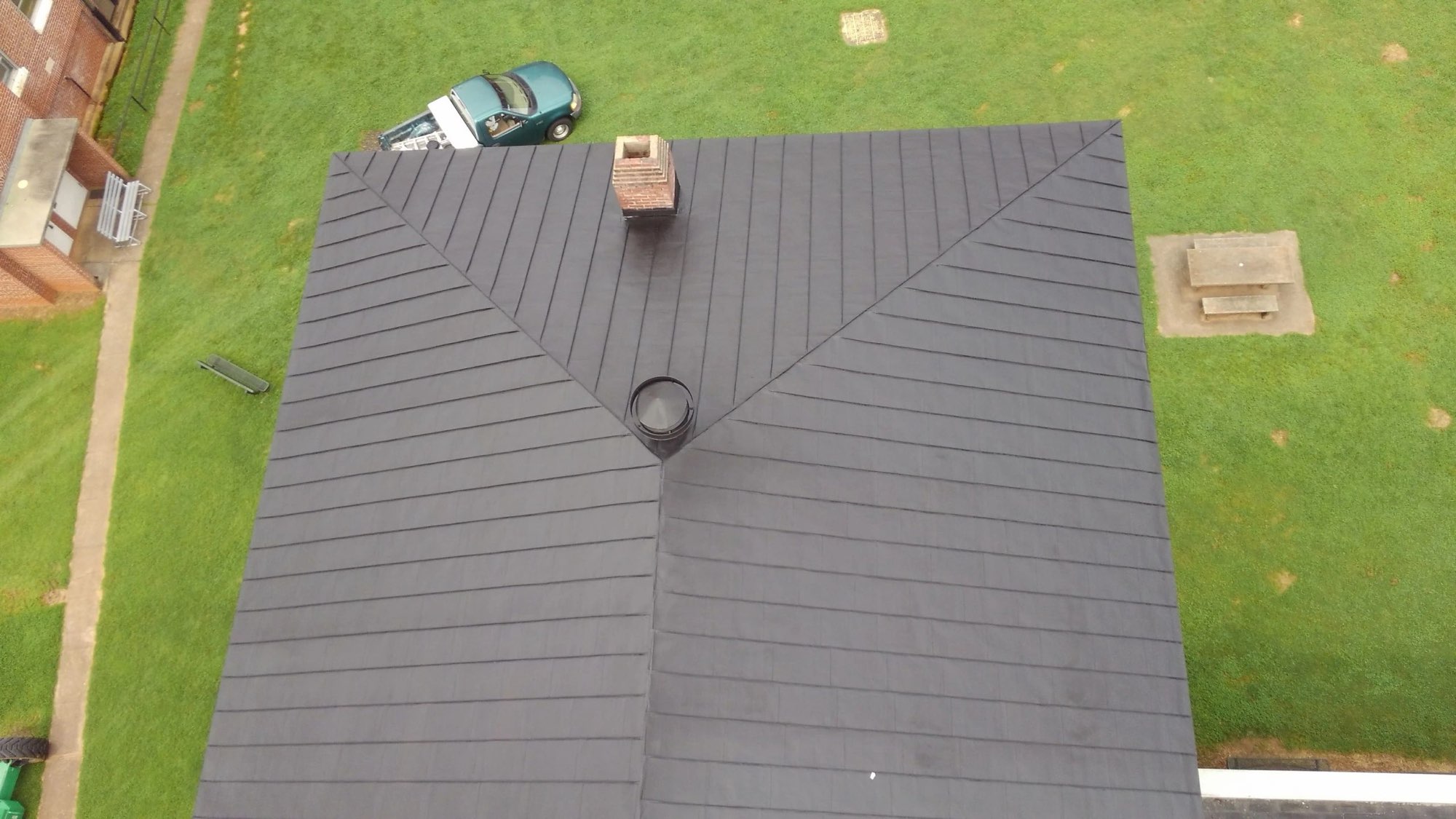 Overhead view of a hip roof with a fresh dark gray coating