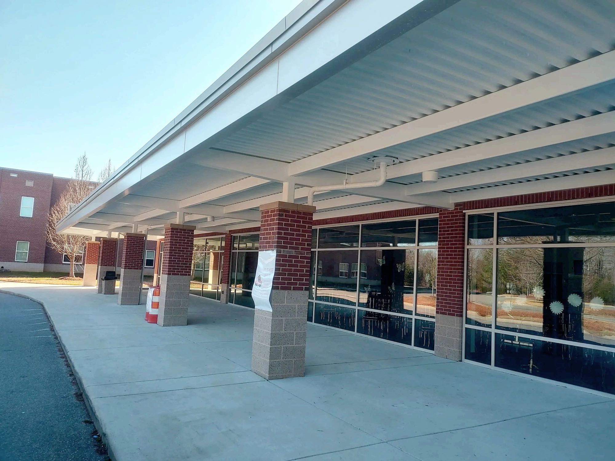 School covered walkway with a freshly painted white canopy on brick columns